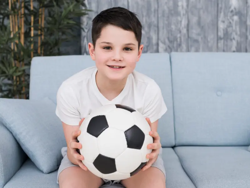 Ein kleiner Junge spielt mit einem Fußball Ein kleiner Junge spielt mit einem Fußball