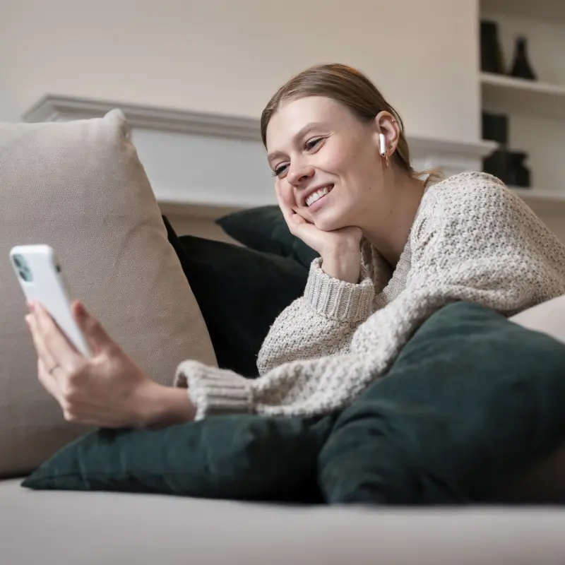 Eine junge Frau schaut auf ihr Smartphone und hat einen Videocall Eine junge Frau schaut auf ihr Smartphone und hat einen Videocall