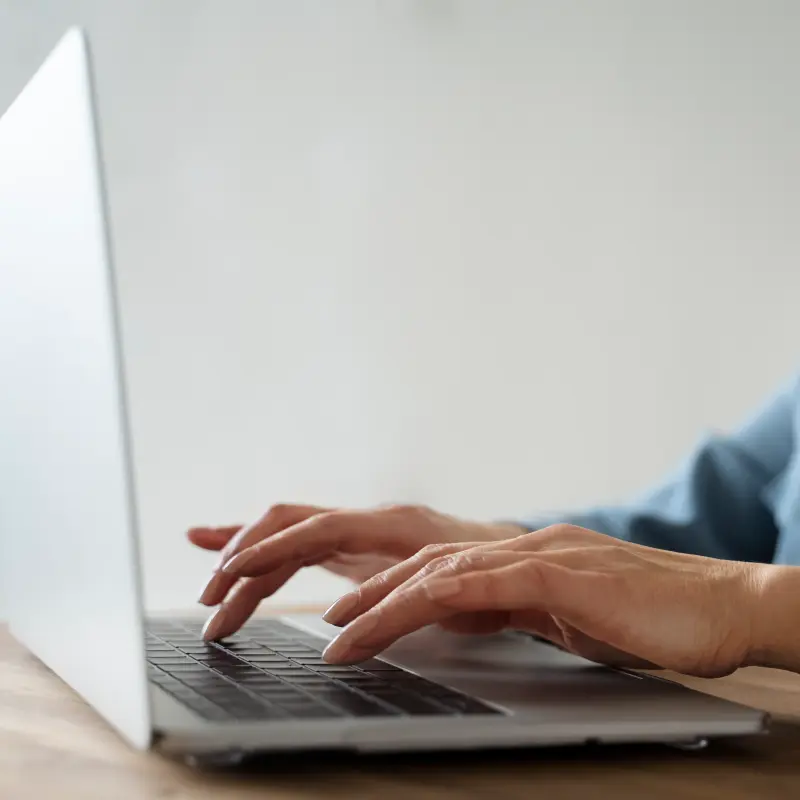 Eine Frau tippt etwas an ihrem Laptop ein Eine Frau tippt etwas an ihrem Laptop ein