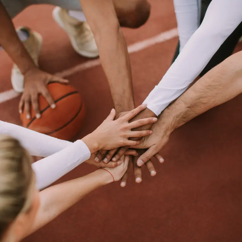 BarmeniaGothaer Gruppenunfallversicherung für Vereine: Mitglieder einer Basketballmannschaft legen ihre Hände aufeinander BarmeniaGothaer Gruppenunfallversicherung für Vereine: Mitglieder einer Basketballmannschaft legen ihre Hände aufeinander
