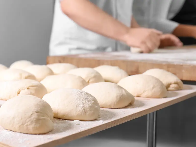 Ein Bäcker bereitet Brötchen vor Ein Bäcker bereitet Brötchen vor