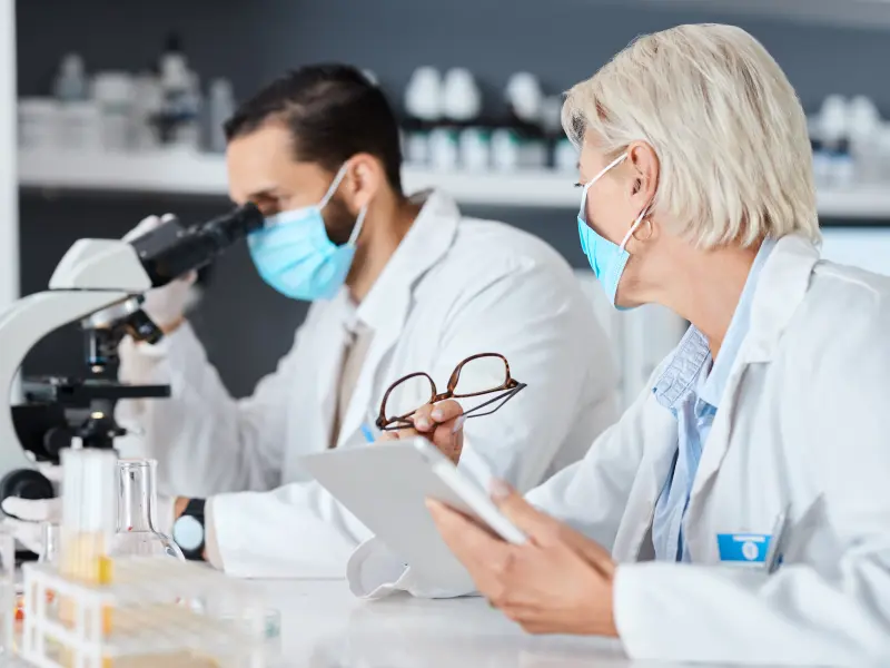 Zwei Chemikanten sitzen in einem Labor und untersuchen Proben Zwei Chemikanten sitzen in einem Labor und untersuchen Proben