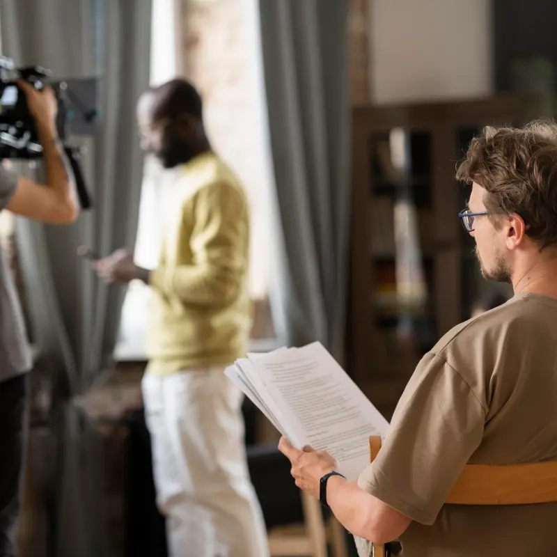 Ein Filmset mit einem Schauspieler, einem Kameramann und einem Regisseur Ein Filmset mit einem Schauspieler, einem Kameramann und einem Regisseur