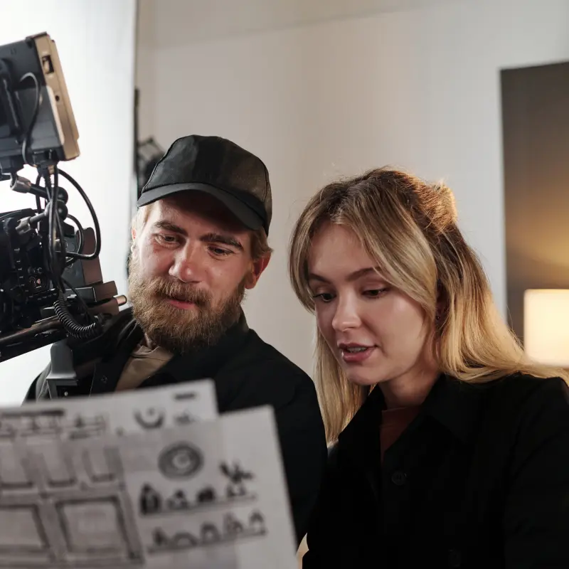 Ein Videograf und eine Schauspielerin schauen gemeinsam auf das Drehbuch Ein Videograf und eine Schauspielerin schauen gemeinsam auf das Drehbuch