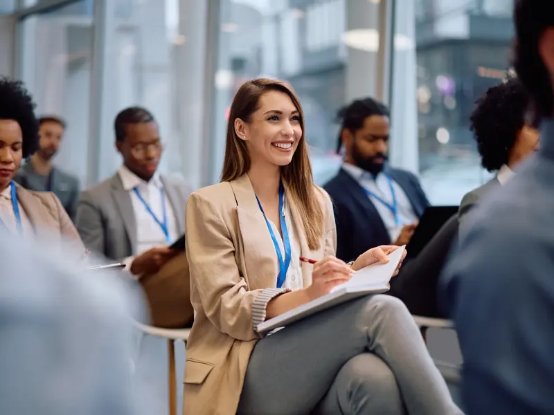 Eine Studentin sitzt in einer Konferenz und schreibt in ihr Notizbuch Eine Studentin sitzt in einer Konferenz und schreibt in ihr Notizbuch