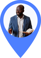 Man in a blue suit holding an open book and gesturing with his hand inside a blue map marker shape.