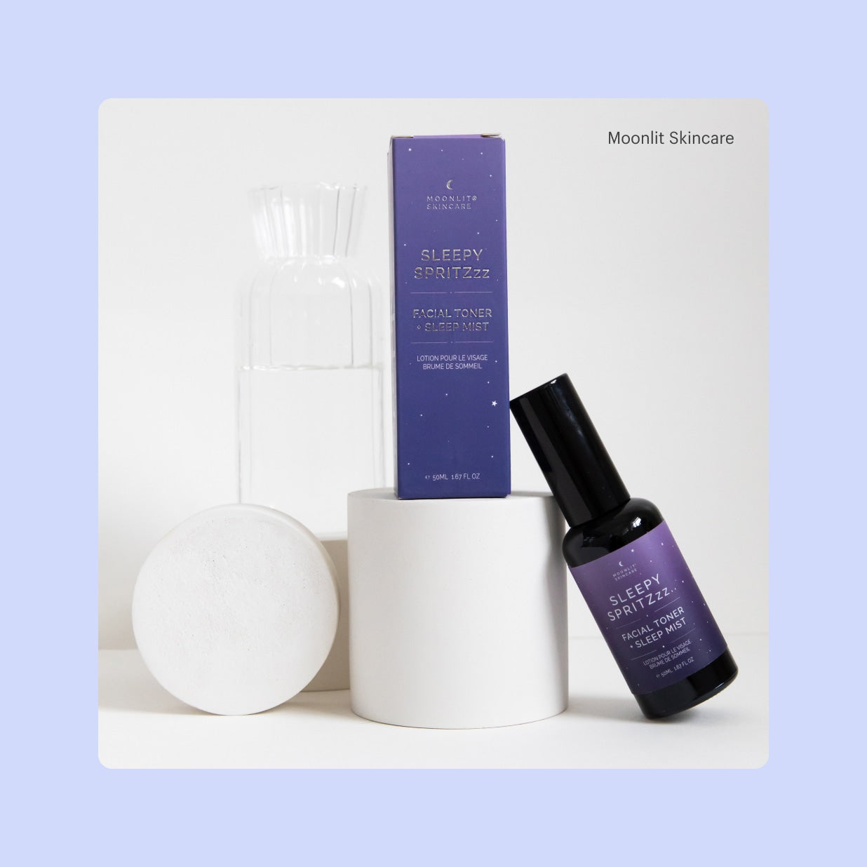 A product display featuring purple package for Moonlit Skincare’s Sleepy Spritzzz.. facial toner, and a small spray bottle of Sleepy Spritzzz.. facial toner