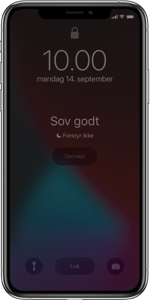 iPhone-skærmen med “Sov godt” og “Forstyr ikke er slået til” i midten. Derunder vises knappen Genveje. Nederst på skærmen vises fra venstre til højre knapperne Lommelygte, Luk og Kamera.