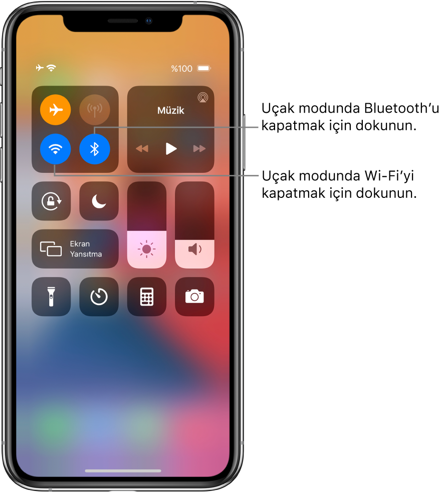Uçak modunun açık olduğu ve sol üst taraftaki denetim grubunun sol alt düğmesine dokunmanın Wi-Fi’yi, aynı grupta sağ alttaki düğmeye dokunmanın Bluetooth’u kapattığını açıklayan belirtme çizgileriyle Denetim Merkezi.