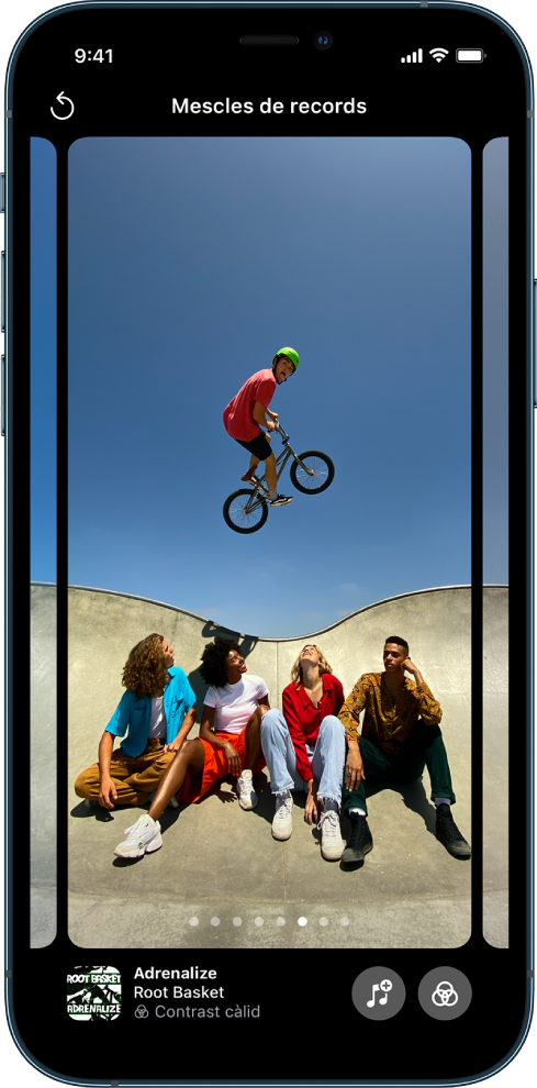 Mescla de records a l’app Fotos. Hi ha una foto del record al centre de la pantalla, a la part inferior de la foto hi ha uns punts que indiquen quina opció de mescla de records es mostra. El sisè punt està ressaltat. A l’angle inferior esquerre hi ha la portada de l’àlbum, el títol de la cançó, el nom de la cançó i el filtre que componen aquesta mescla de records. A l’angle inferior dret hi ha els botons Música i Filtres. A l’angle superior esquerre hi ha el botó Enrere.