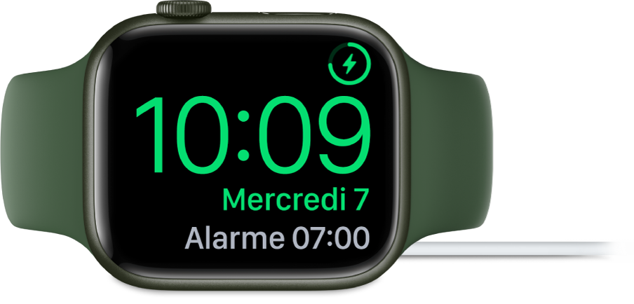 Apple Watch placée sur sa tranche et connectée au chargeur. L’écran montre le symbole de recharge dans le coin supérieur droit, l’heure actuelle en dessous et l’heure du prochain réveil.