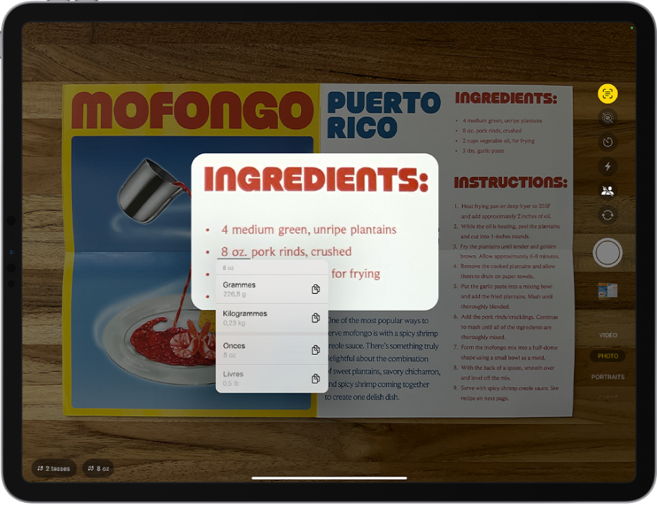 Écran Appareil photo avec une recette dans le cadre de l’appareil photo. Du texte dans le menu est sélectionné et le texte souligné montre des options de conversion pour 8 onces. En bas de l’écran se trouvent les boutons d’action rapide permettant de convertir 2 tasses et 8 onces