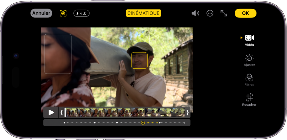 L’écran Modifier d’une vidéo en mode Cinématique en orientation paysage. En haut à gauche de l’écran se trouvent le bouton Annuler, le bouton Manuel cinématique et le bouton Réglage de la profondeur. En haut au centre de l’écran, le bouton Cinématique est sélectionné. En haut à droite de l’écran se trouvent le bouton Volume, le bouton Plus d’options, le bouton Activer le mode plein écran et le bouton Terminé. La vidéo est au centre de l’écran et un cadre entoure le sujet de la mise au point. Sous la vidéo se trouve le visualiseur d’image qui affiche le repère de la vidéo où la mise au point du sujet change. Les boutons de modification se trouvent sur le côté droit de l’écran, de haut en bas : Vidéo, Ajuster la couleur, Filtres, et Recadrer.