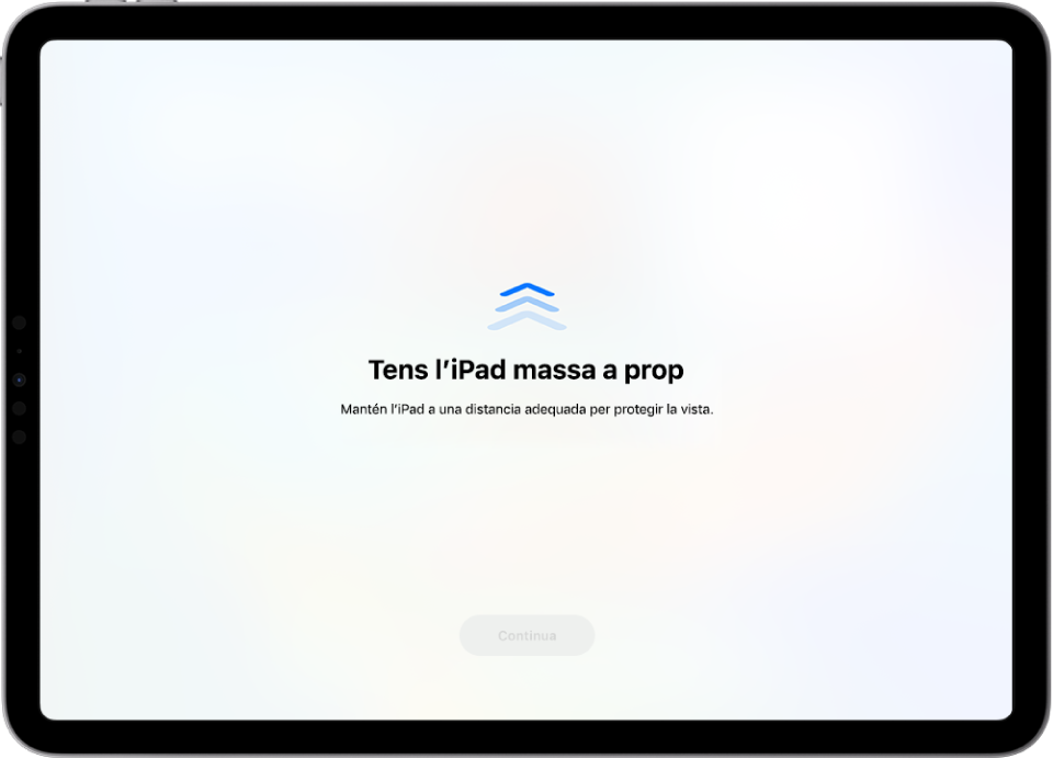 A la pantalla s’informa que estàs mirant l’iPad de massa prop i que cal que te l’allunyis per protegir-te la vista. L’avís tapa tota la pantalla i impedeix que continuïs. Hi ha un botó “Continua” que s’activa quan allunyes l’iPad fins a una distància segura.