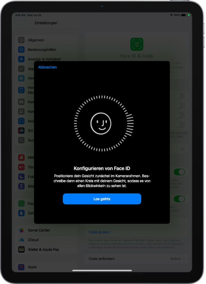 Der Konfigurationsbildschirm für die Face ID-Erkennung. Auf dem Bildschirm ist ein lächelndes Gesicht zu sehen, das von einem Kreis umgeben ist. Darunter weist Text den:die Benutzer:in an, den Kopf langsam zu bewegen, um den Kreis zu schließen. Unten auf dem Bildschirm wird eine Taste für „Los gehts“ angezeigt.