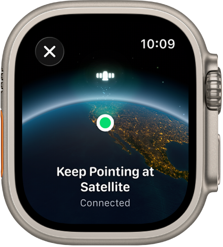 Una pantalla que muestra el icono de un satélite sobre una vista curva de la Tierra, un indicador de conexión verde y el texto "Sigue apuntando al satélite".