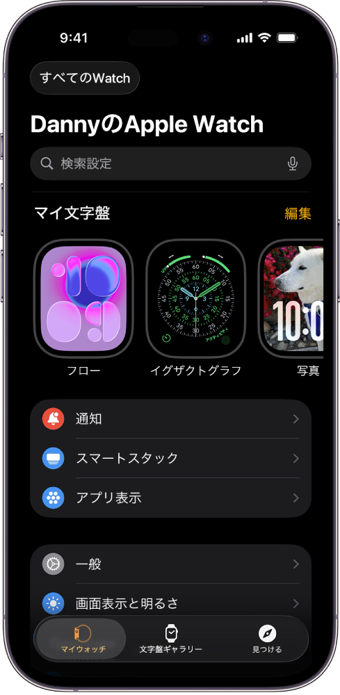 iPhoneのApple Watchアプリの「マイウォッチ」画面が開いています。上部に文字盤、その下に各種の設定が表示されています。Apple Watchアプリ画面の下部には3つのタブがあります。左の「マイウォッチ」タブは、Apple Watchの設定に移動します。次の「文字盤ギャラリー」では、使用できる文字盤とコンプリケーションを見て回ることができます。その次の「見つける」では、Apple Watchの詳細を確認できます。