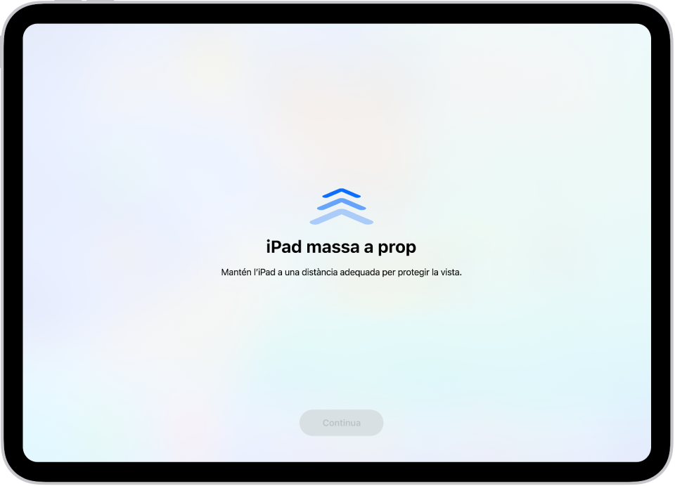 A la pantalla s’informa que estàs mirant l’iPad de massa prop i que cal que te l’allunyis per protegir-te la vista. L’avís tapa tota la pantalla i impedeix que continuïs. Hi ha un botó “Continua” que s’activa quan allunyes l’iPad fins a una distància segura.