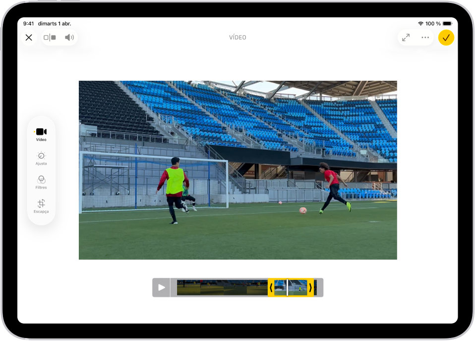 La pantalla d’edició de l’app Fotos en què s’està reproduint un vídeo al centre. El visor de fotogrames del vídeo apareix a la part inferior del vídeo i es veu un contorn de color groc seleccionant els fotogrames que s’inclouran al vídeo escurçat. Al costat esquerre de la pantalla hi ha els botons “Vídeo”, “Ajusta”, “Filtres” i “Escapça”; el botó “Vídeo” està seleccionat.