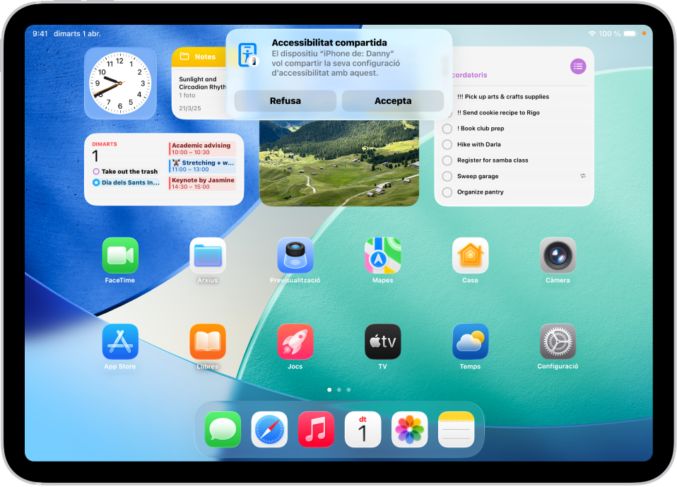 Un iPad mostra una notificació avisant que l’iPhone de l’Adrià sol·licita accedir a la configuració d’accessibilitat.