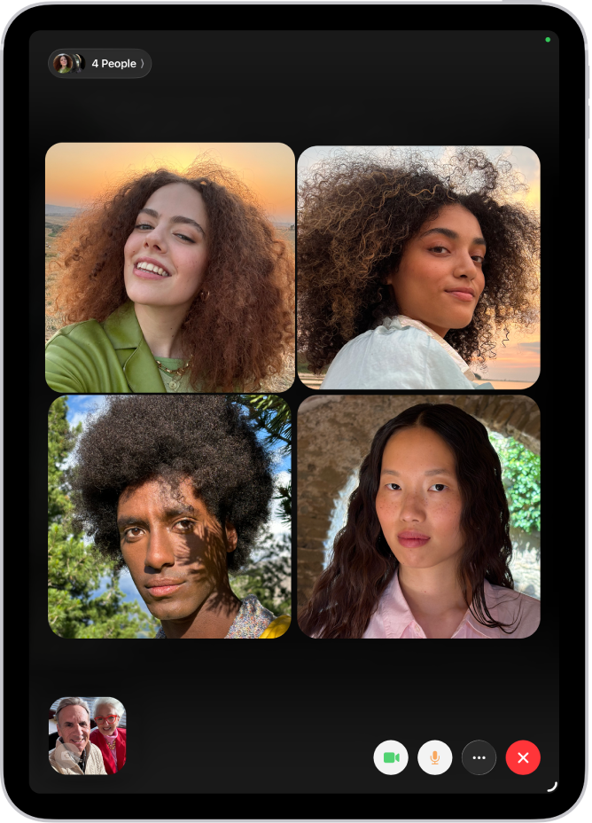 Group FaceTime zvans ar četriem dalībniekiem atsevišķās rūtīs ekrāna augšdaļā. Rūtī apakšā pa kreisi ir redzami divi papildu dalībnieki. Apakšējā labajā stūrī ir FaceTime vadīklas: pogas Video, Microphone, More un End Call.
