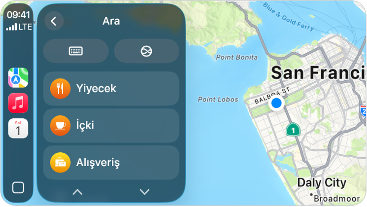 San Francisco’nun haritasını gösteren bir CarPlay ekranı. Sağ tarafta konum, 3B, tehlike bildir ve büyüt düğmeleri var. Aşağıda Ara ve Hedef düğmeleri var.