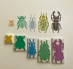 four rubber stamps with different types of bugs and bug silhouettes on them, sitting next to each other