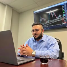 a man sitting in front of a laptop computer