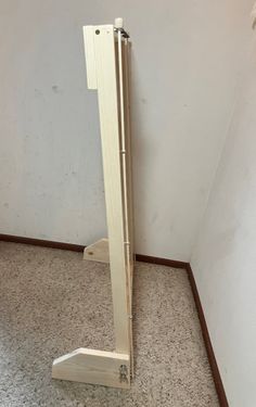 a pair of wooden stands on the floor in front of a white wall and carpet