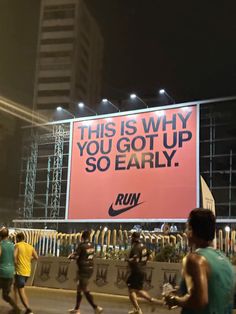 people running in front of a large advertisement