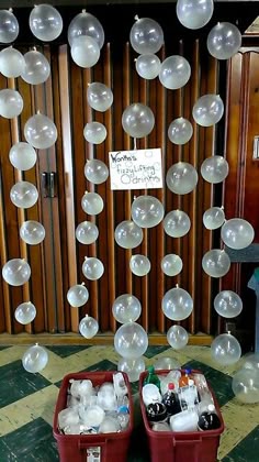 two red buckets filled with lots of white bubbles next to a sign on the wall