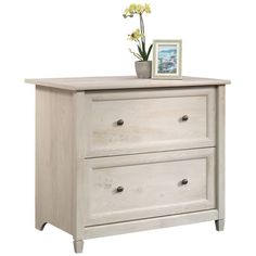 a white dresser with two drawers and a flower pot on top of the bottom drawer