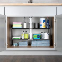 an open cabinet with lots of cleaning supplies
