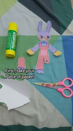 scissors, glue, and paper cut out to look like a cartoon character on a quilt