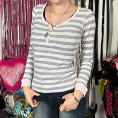 a woman standing in front of a rack of clothes