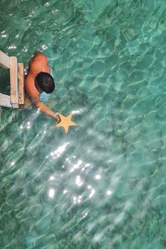 Man holding a starfish underwater in Utila, Honduras