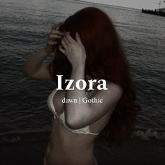 a woman with red hair is standing in front of the water