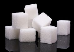 white sugar cubes stacked on top of each other in front of a black background