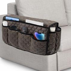 a couch that has some items in the pocket on it's back and is attached to an armrest