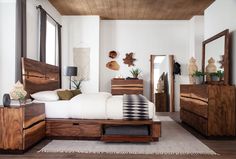 a bed room with a neatly made bed and lots of wooden furniture on the floor