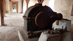 an old machine is sitting in the middle of a room with exposed ceiling and walls