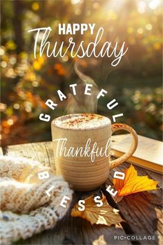 a cup of coffee sitting on top of a wooden table next to a book with the words happy thursday grateful