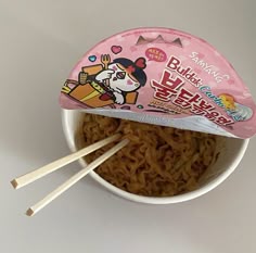 there is noodle noodles in the bowl with chopsticks sticking out of it