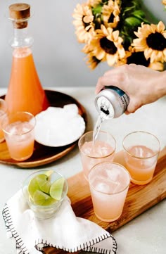 a person pouring drinks into glasses on a tray