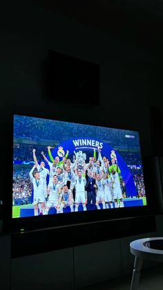 a large television screen with the winners on it's display in a dark room