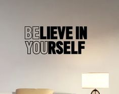 a bedroom with a bed and a wall sticker that says, be believe in yourself