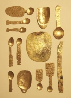an assortment of gold colored utensils and spoons