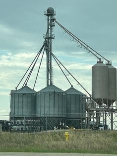 an industrial area with large silos and yellow fire hydrant in the foreground