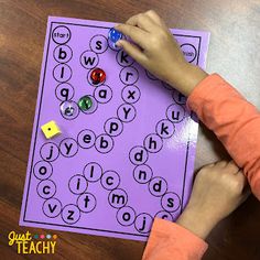 a young child is playing with an activity for sight and phonicic practice on the table