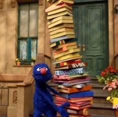 the sesame street character is leaning up against a stack of books in front of a house